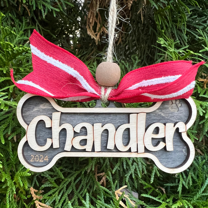 wood ornament shaped like a dog bone with pets name overlayed, option to add year